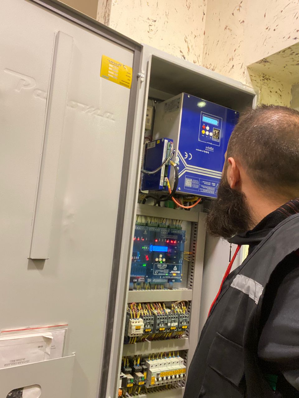 Technicien CM-Ascenseurs devant une armoire de commande